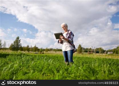 farming, agriculture, technology and people concept - happy senior woman with tablet pc computer at county or farm. senior woman with tablet pc computer at county