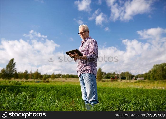 farming, agriculture, technology and people concept - senior man with tablet pc computer at county or farm. senior man with tablet pc computer at county