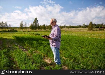 farming, agriculture, technology and people concept - senior man with tablet pc computer at county or farm. senior man with tablet pc computer at county
