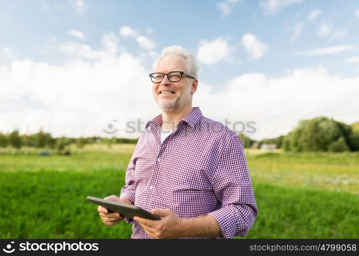 farming, agriculture, technology, old age and people concept - happy senior man with tablet pc computer at county or farm