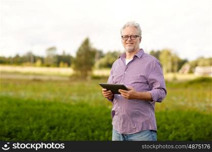 farming, agriculture, technology, old age and people concept - happy senior man with tablet pc computer at county or farm