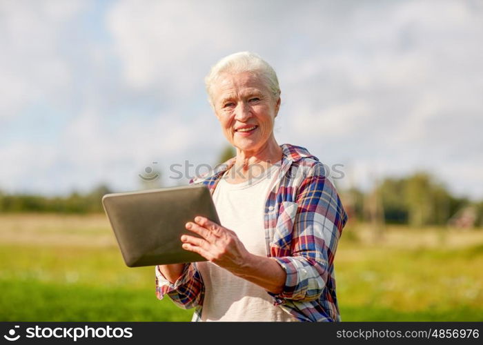 farming, agriculture, technology, old age and people concept - happy senior woman with tablet pc computer at county or farm