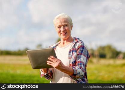 farming, agriculture, technology, old age and people concept - happy senior woman with tablet pc computer at county or farm