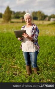 farming, agriculture, technology, old age and people concept - happy senior woman with tablet pc computer at county or farm