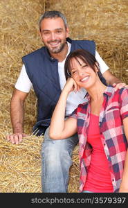 Farming couple sitting on hay