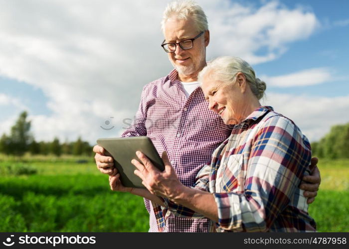 farming, gardening, agriculture and people concept - happy senior couple with tablet pc computer at summer farm