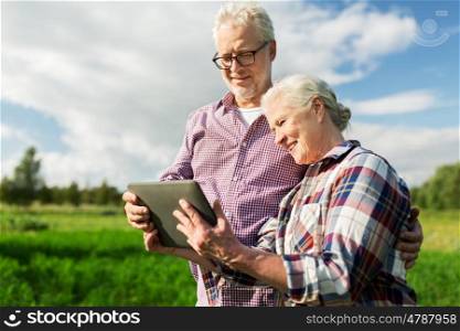 farming, gardening, agriculture and people concept - happy senior couple with tablet pc computer at summer farm