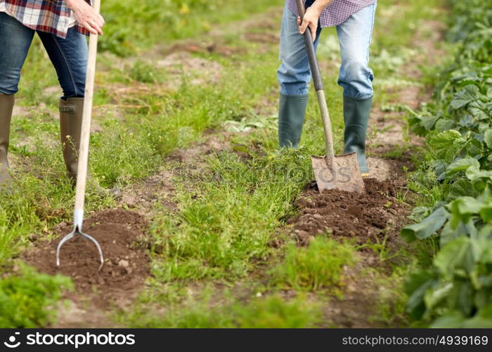 farming, gardening, agriculture and people concept - senior couple with shovels at garden or farm. senior couple with shovels at garden or farm