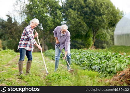 farming, gardening, agriculture and people concept - senior couple with shovels at garden or farm. senior couple with shovels at garden or farm