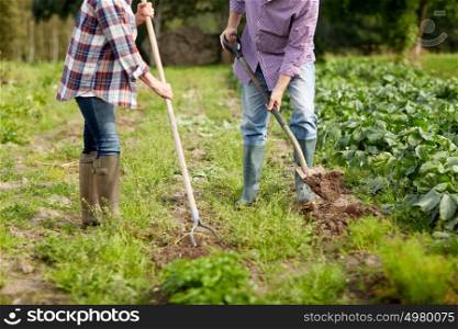 farming, gardening, agriculture and people concept - senior couple with shovels at garden or farm. senior couple with shovels at garden or farm