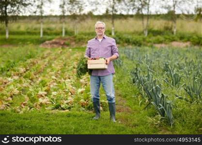 farming, gardening, agriculture and people concept - senior man with box of vegetables at farm garden. old man with box of vegetables at farm garden