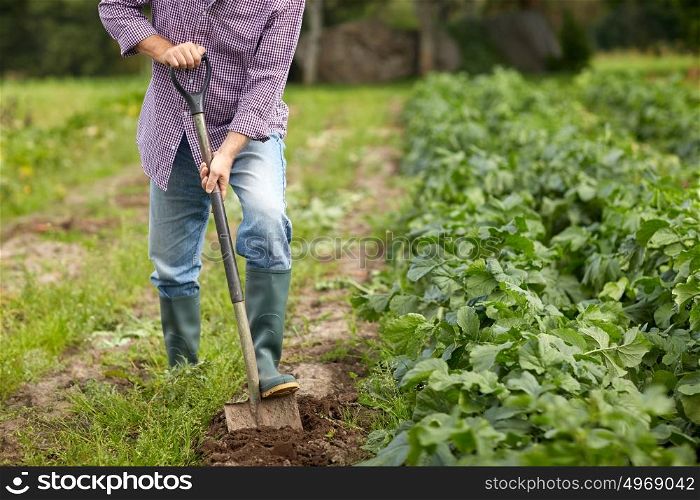 farming, gardening, agriculture and people concept - senior man with shovel digging garden bed or farm. senior man with shovel digging garden bed or farm