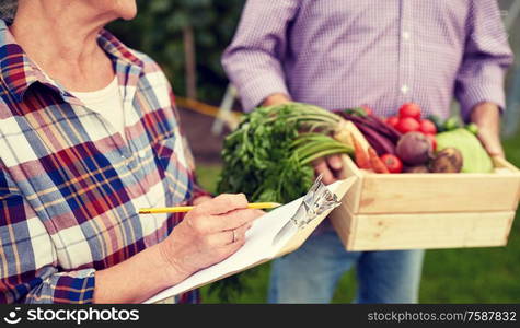 farming, gardening, harvesting, agriculture and people concept - senior couple with box of vegetables and clipboard at farm or garden. senior couple with box of vegetables at farm