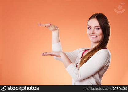 Fashion and advertisement concept. Smiling woman holding open palm empty hand showing copy space holding your product.