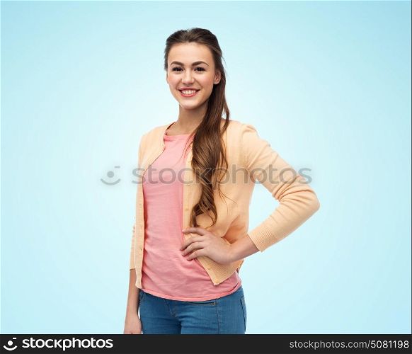 fashion and people concept - happy smiling young woman in cardigan over blue background. happy smiling young woman in cardigan