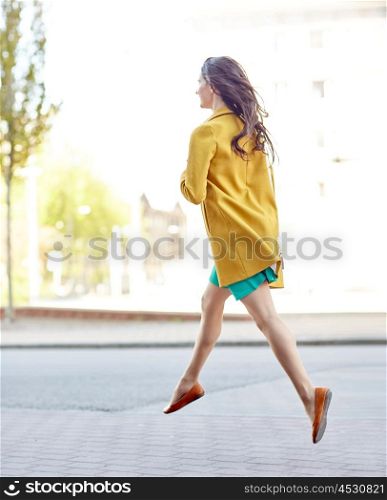 fashion and people concept - happy young woman or teenage girl legs flying above pavement on city street. young woman or teenage girl legs on city street
