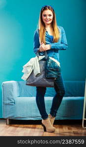 Fashion and shopping. Woman long hair wearing denim with bag. Attractive girl holding handbag with jeans clothes, buying. Blue color