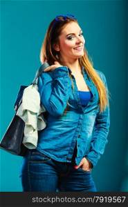 Fashion and shopping. Woman long hair wearing denim with bag. Attractive girl holding handbag with jeans clothes, buying. Blue color
