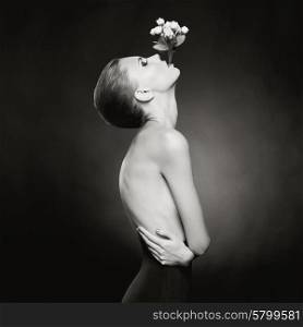 Fashion art photo of elegant naked lady with flowers in her mouth