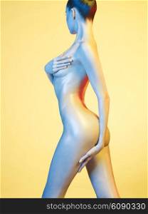 Fashion art photo of elegant nude model in the light colored spotlights
