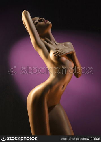 fashion art photo of elegant nude model in the light colored spotlights