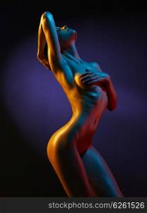 fashion art photo of sexy nude stripper in the night-club. Perfect female body with oil skin