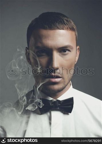 Fashion art portrait of a handsome man smoking