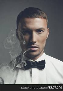 Fashion art portrait of a handsome man smoking