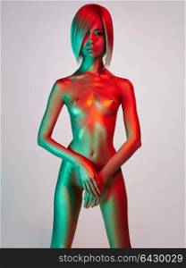 Fashion art studio photo of elegant nude model in the light colored spotlights. Fashion and beauty. Conceptual image. Metallic art, body art. Slim, fit woman. Gold skin