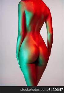 Fashion art studio photo of elegant nude model in the light colored spotlights. Fashion and beauty. Conceptual image. Metallic art, body art. Slim, fit woman. Gold skin