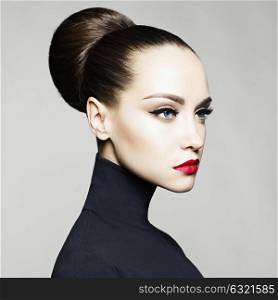 Fashion art studio portrait of beautiful elegant woman in black turtleneck. Hair is collected in high beam. Elegant ballet style