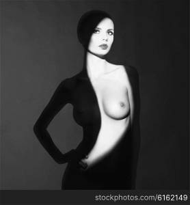 Fashion art studio portrait of elegant naked lady with shadow on her body
