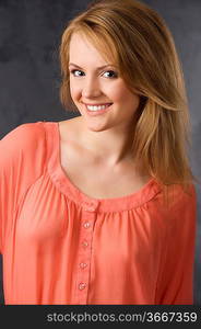 fashion beauty portrait of young woman with hair style over dark background wearing an orange shirt