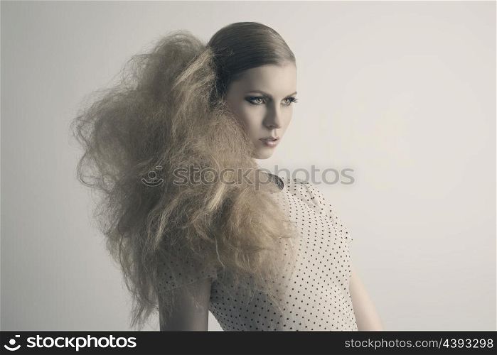 fashion blonde woman with modern creative hair-style and cute make-up posing with sensual expression