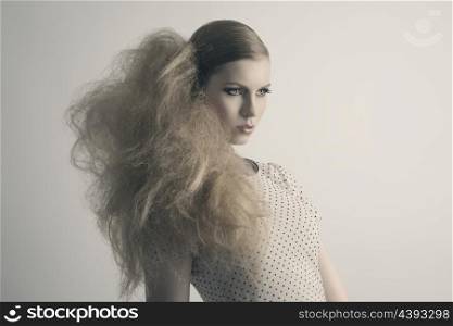 fashion blonde woman with modern creative hair-style and cute make-up posing with sensual expression