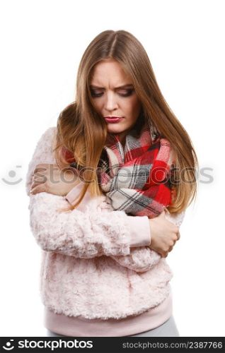 Fashion, clothes and clothing concept. Grumpy woman feeling cold wearing warm scarf warming herself up. Grumpy woman feeling cold wearing warm scarf
