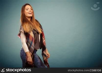 Fashion clothing concept. Beautiful model posing at studio. Girl is wearing denim trousers and checkered scarf. . Beautiful model posing at studio.