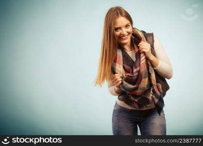 Fashion clothing concept. Beautiful model posing at studio. Girl is wearing denim trousers and checkered scarf. . Beautiful model posing at studio.