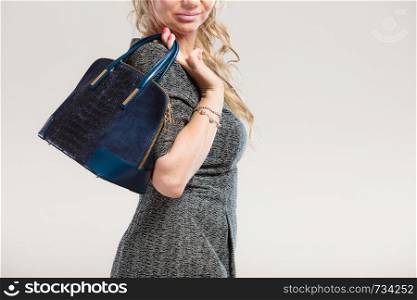 Fashion clothing people concept. Chic woman with black, leather handbag. Female wearing elegant dress.. Chic woman with handbag.