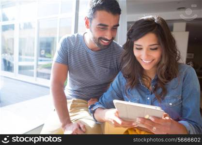 Fashion couple using a tablet with sunbeams and lens flare