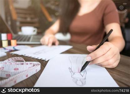 fashion / creative designer working with sketching notebook at modern home studio, selective focus