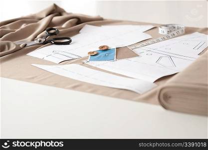 Fashion designer studio with professional equipment on desk, cloth, scissors