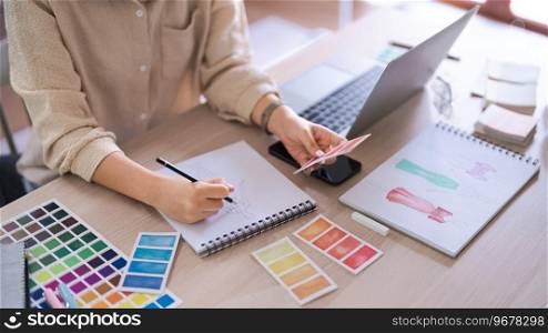 Fashion designer women choose color swatch s&le to sketching in paper for creative new collection.