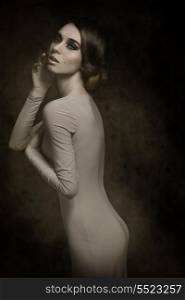 fashion elegant girl posing with romantic expression, elegant hair-style and gray dress. Slim perfect body