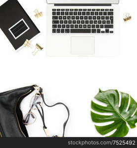 Fashion flat lay for social media. Office desk. Laptop, green leaf, notebook on white background.
