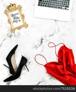 Fashion flat lay for social media with laptop. Red dress, black high heels, golden frame, notebook