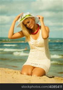 Fashion, happiness and lifestyle concept Beautiful girl in hat on beach. Young woman relaxing on the sea coast.