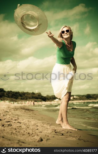 Fashion, happiness and lifestyle concept Beautiful girl in hat walking on beach. Young woman relaxing on the sea coast.