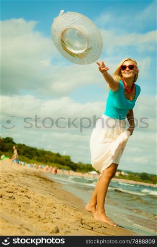 Fashion, happiness and lifestyle concept Beautiful girl in hat walking on beach. Young woman relaxing on the sea coast.