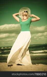 Fashion, happiness and lifestyle concept Beautiful girl in hat walking on beach. Young woman relaxing on the sea coast.